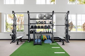 A gym with a green mat and weights  at The Hadley - North Port, FL Apartments, North Port 34287